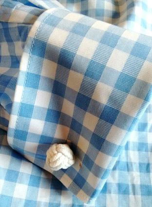 puño de camisa con el gemelo colocado en el ojal